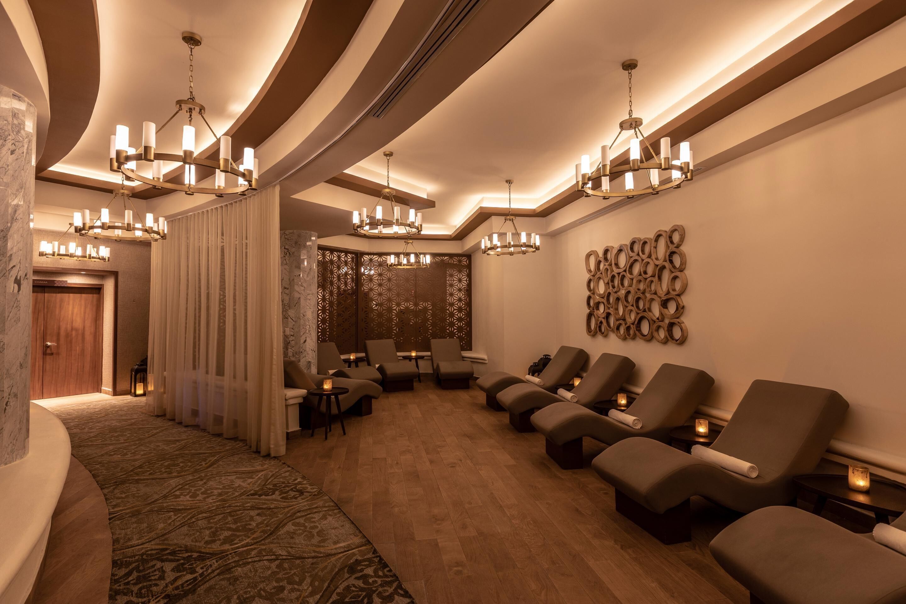 A spa area with multiple massage chairs, ambient lighting, and a decorative wall.