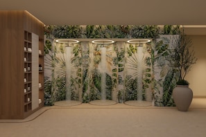 A room with a tropical-themed wall mural, a wooden shelving unit, and a large vase.