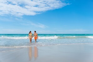 On the beach, white sand, sun loungers, beach umbrellas