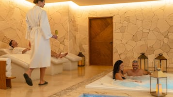 A spa with a stone wall, a wooden door, and a hot tub.
