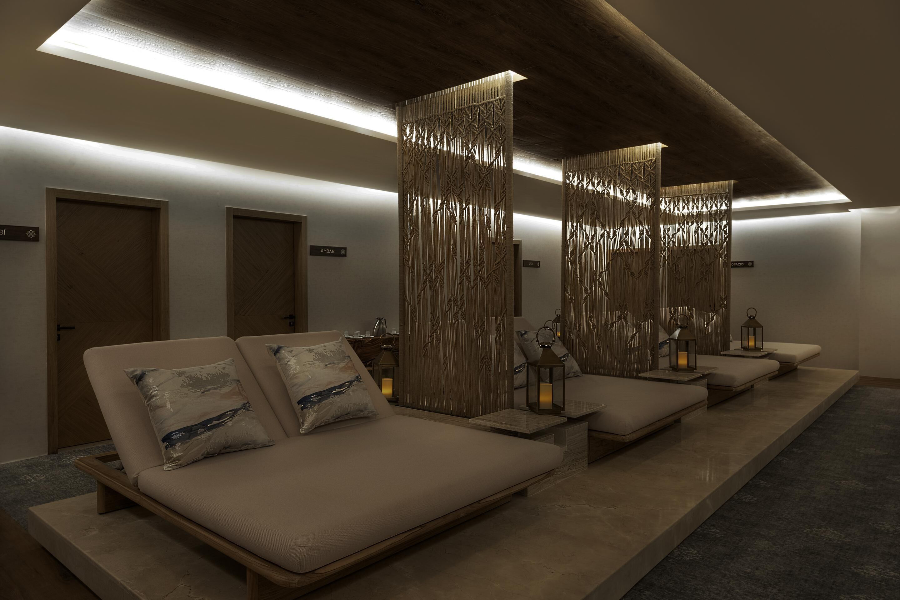 A modern spa room with a long bench, wooden partitions, and a ceiling light.