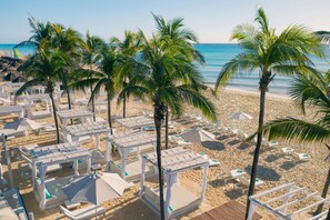 On the beach, white sand, sun loungers, beach umbrellas