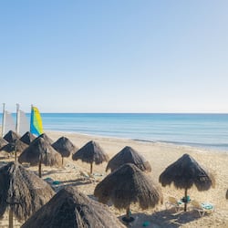 Am Strand, weißer Sandstrand, Liegestühle, Sonnenschirme