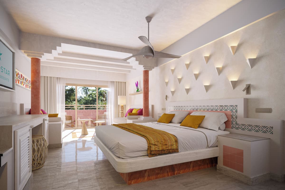 Een moderne hotelkamer met een groot bed, een plafondventilator, een balkon met uitzicht en een decoratieve wand.