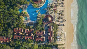 An aerial view of a resort with multiple swimming pools, a beach, and a series of connected buildings. - Iberostar Waves Quetzal - All Inclusive (Playa del Carmen)
