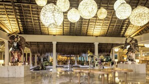 A spacious lobby with a high ceiling, large chandeliers, and a thatched roof. - Iberostar Waves Quetzal - All Inclusive (Playa del Carmen)