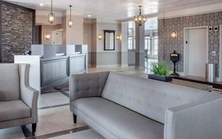 A modern lobby with a grey sofa, a reception desk, and a stone accent wall.