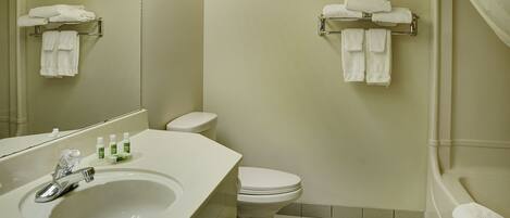 A bathroom with a sink, toilet, and towel racks.