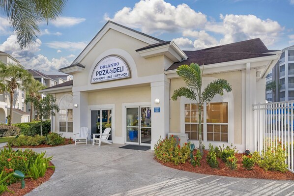 Un edificio con un letrero que dice 'Orlando Pizza & Deli', que incluye una tienda de conveniencia, bar y tienda de regalos.