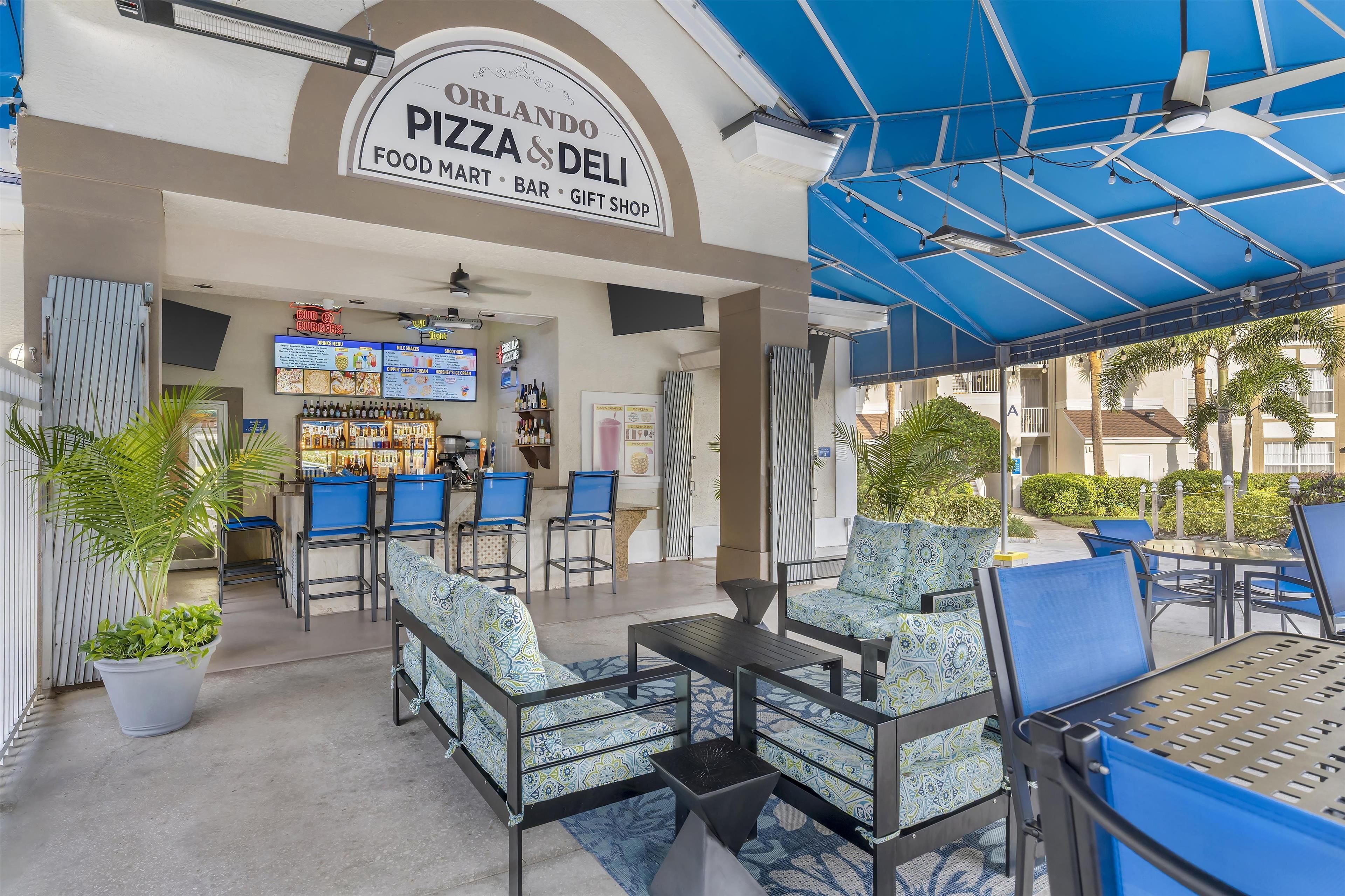 An outdoor seating area with tables and chairs, a food mart, and a gift shop.