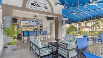 An outdoor seating area with tables and chairs, a food mart, and a gift shop.