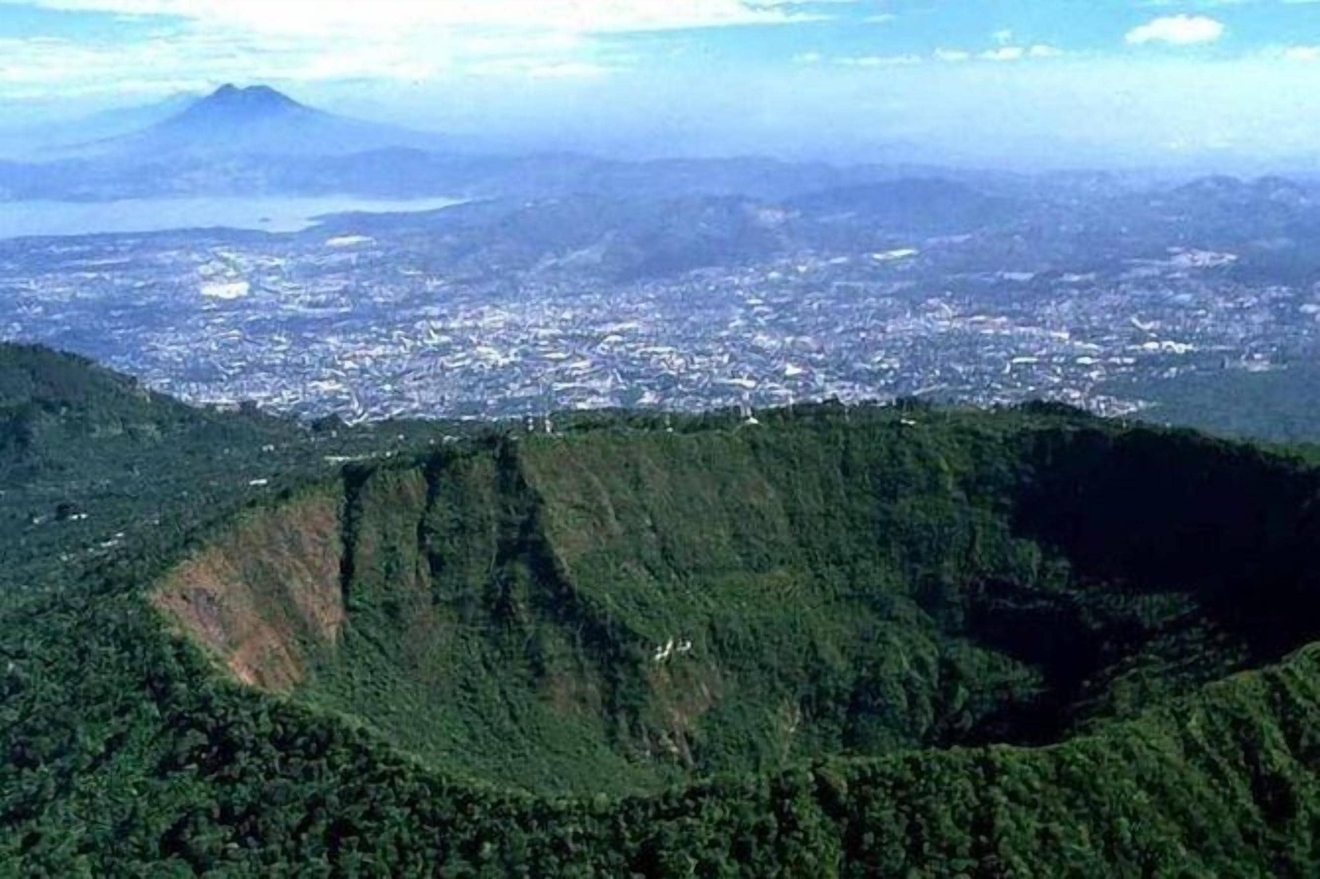 A mountainous landscape with a city in the background.
