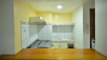 A kitchen with white cabinets, a stove, and a wooden countertop.