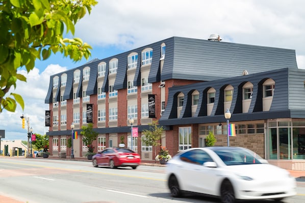 A multi-story building with a modern architectural design, featuring a mix of brick and siding exteriors, large windows, and a flat roof.