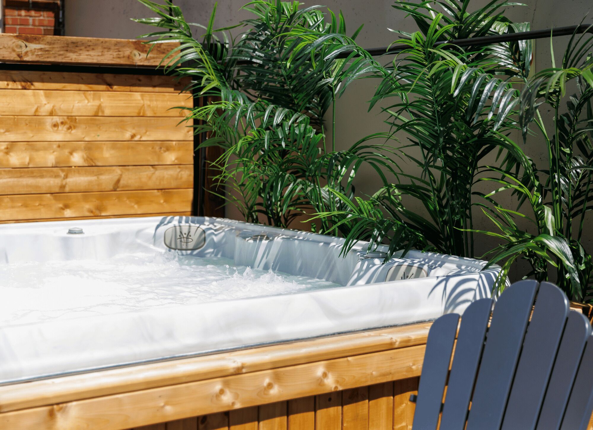A hot tub with a wooden deck and surrounding greenery.