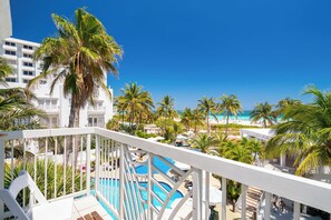 Ein Resort mit Poolbereich, Palmen und Blick auf den Strand.