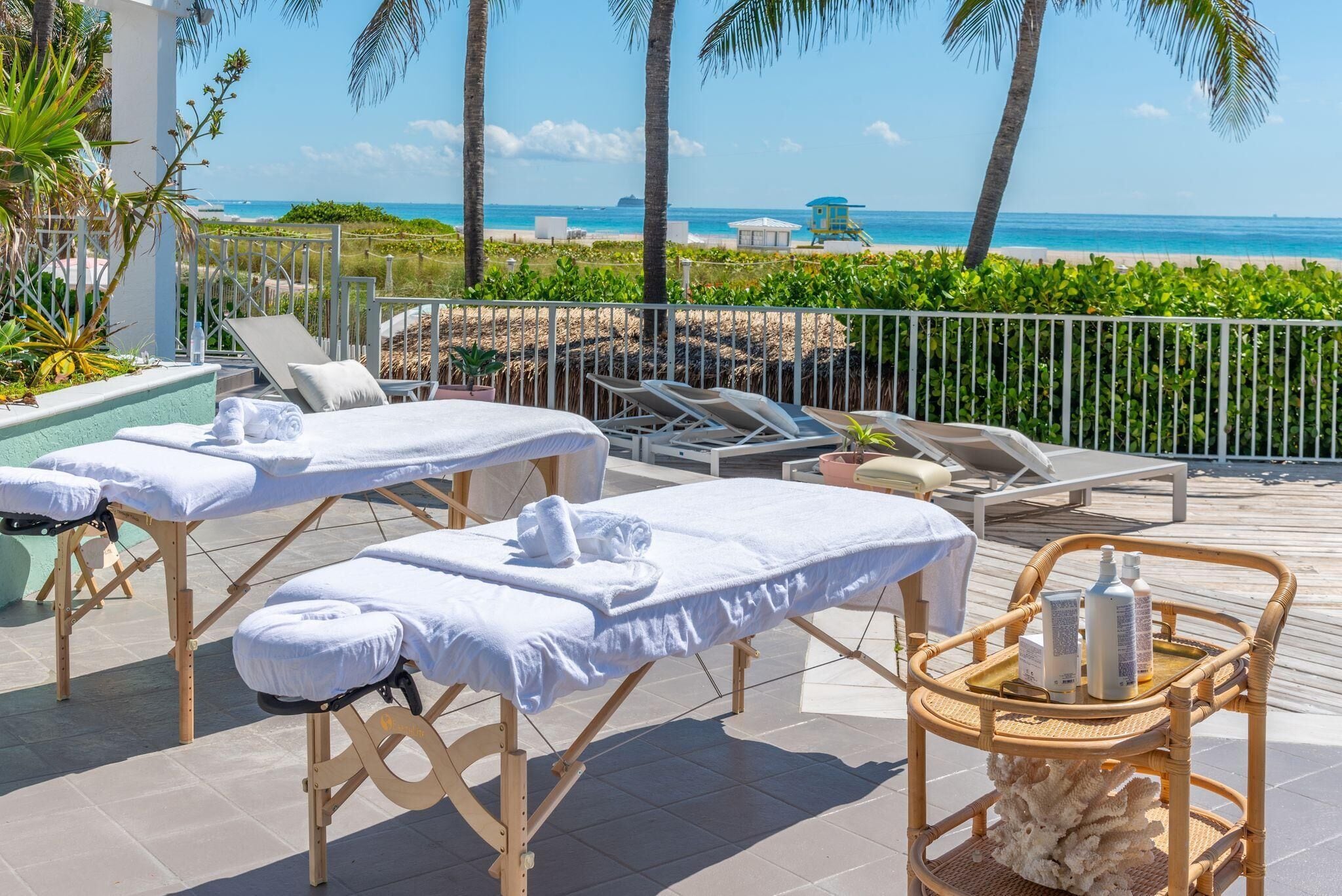 A beachside spa area with massage tables, lounge chairs, and a view of the ocean.