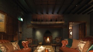 Une pièce chaleureuse avec des canapés en cuir, une table basse en bois et une cheminée.