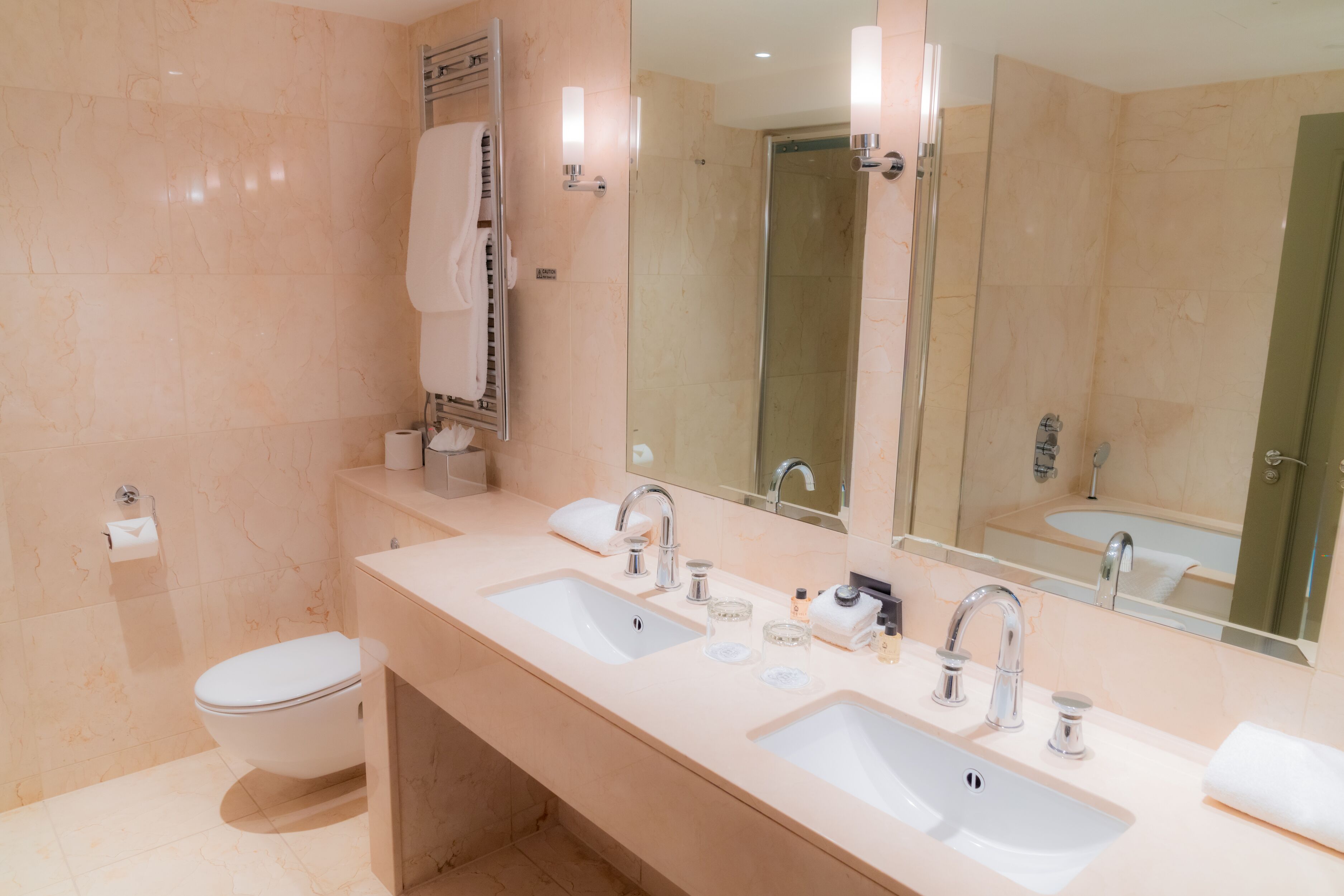 A modern bathroom with two sinks, a toilet, and a glass-enclosed shower.