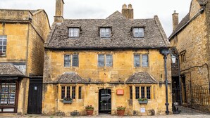 Un bâtiment historique en pierre, doté d’une entrée centrale, de nombreuses fenêtres et d’un toit à deux versants de style traditionnel.