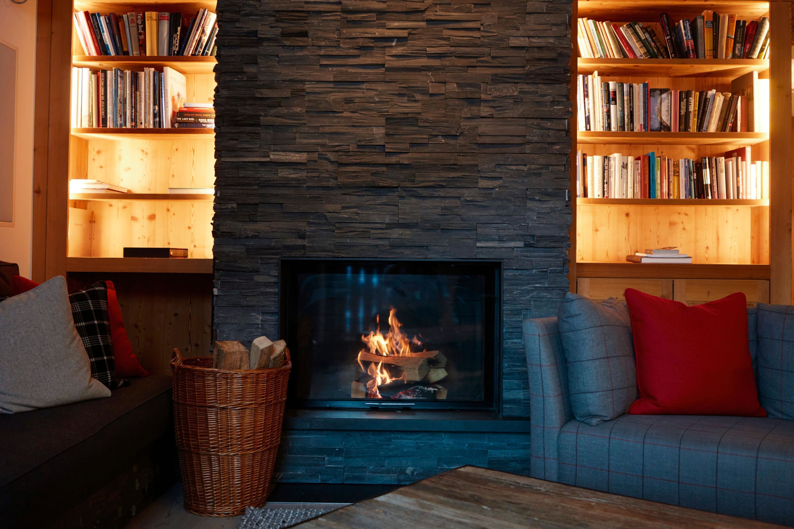 Ein gemütliches Wohnzimmer mit Kamin, Bücherregalen und einer Couch.
