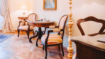 Un comedor con una mesa de madera, sillas a rayas, un cuadro en la pared y una lámpara.