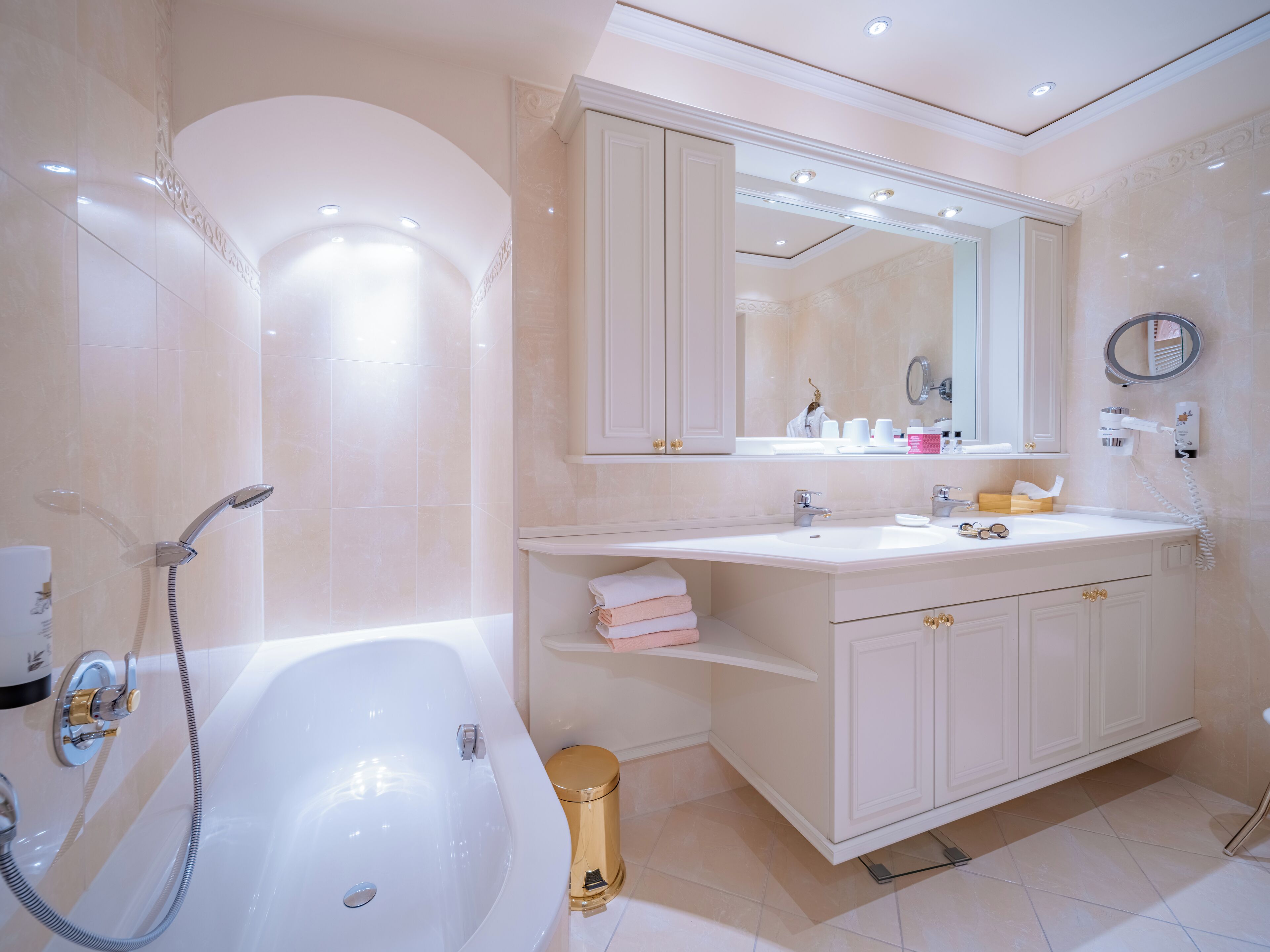 A modern bathroom with a bathtub, a vanity with a mirror, and a toilet.