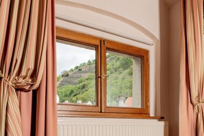 A room with a window overlooking a green hillside. - Hotel Schloss Durnstein (Durnstein)