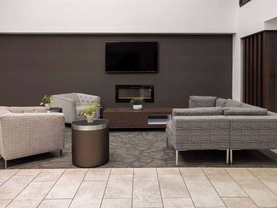 A modern living room with a sofa set, a coffee table, and a flat-screen TV mounted on the wall.