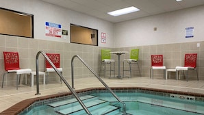 A swimming pool area with a lifeguard stand, chairs, and spa rules sign. - Comfort Inn Saint Paul East (Oakdale)