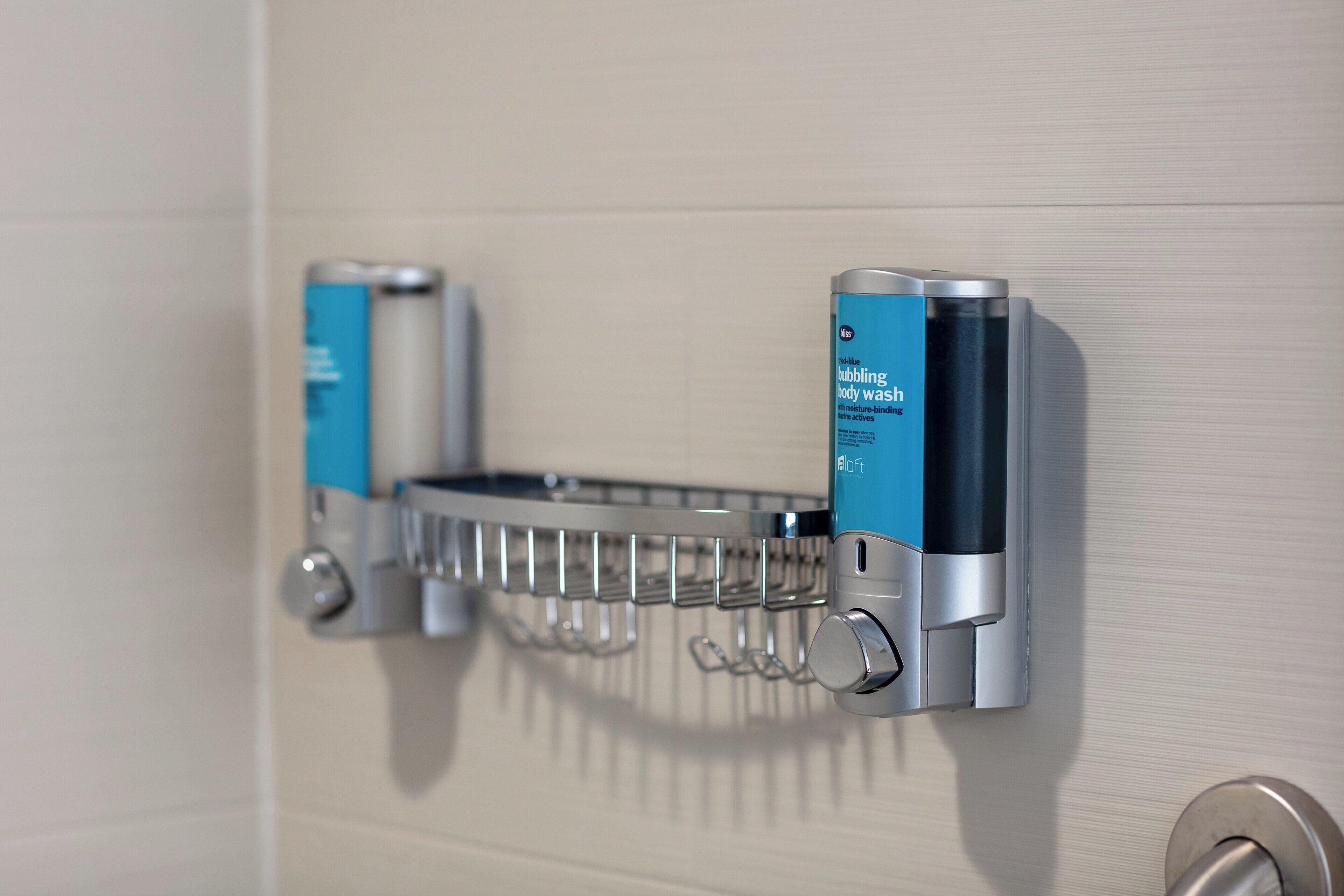 A bathroom with a soap dispenser mounted on the wall.
