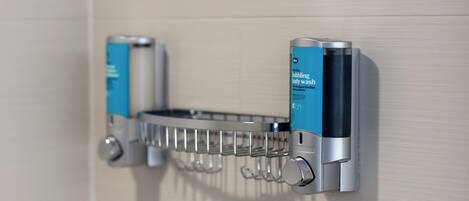 A bathroom with a soap dispenser mounted on the wall.