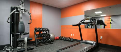 Una palestra con tapis roulant, macchinari per pesi e pesi liberi.