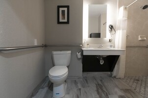 A bathroom with a toilet, sink, and shower.