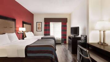 A hotel room with two beds, a TV, a desk, and a chair.