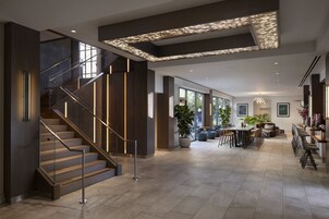 A spacious interior with a staircase, a dining area, and a large window providing natural light.