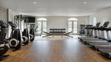 A gym with treadmills, elliptical machines, and weight equipment.