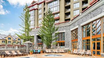 Una piscina techada, una piscina al aire libre, sombrillas