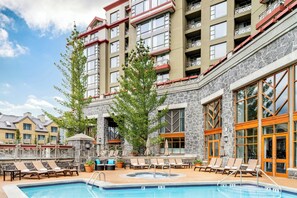 Relax by the pool surrounded by lush greenery and comfortable lounge chairs.