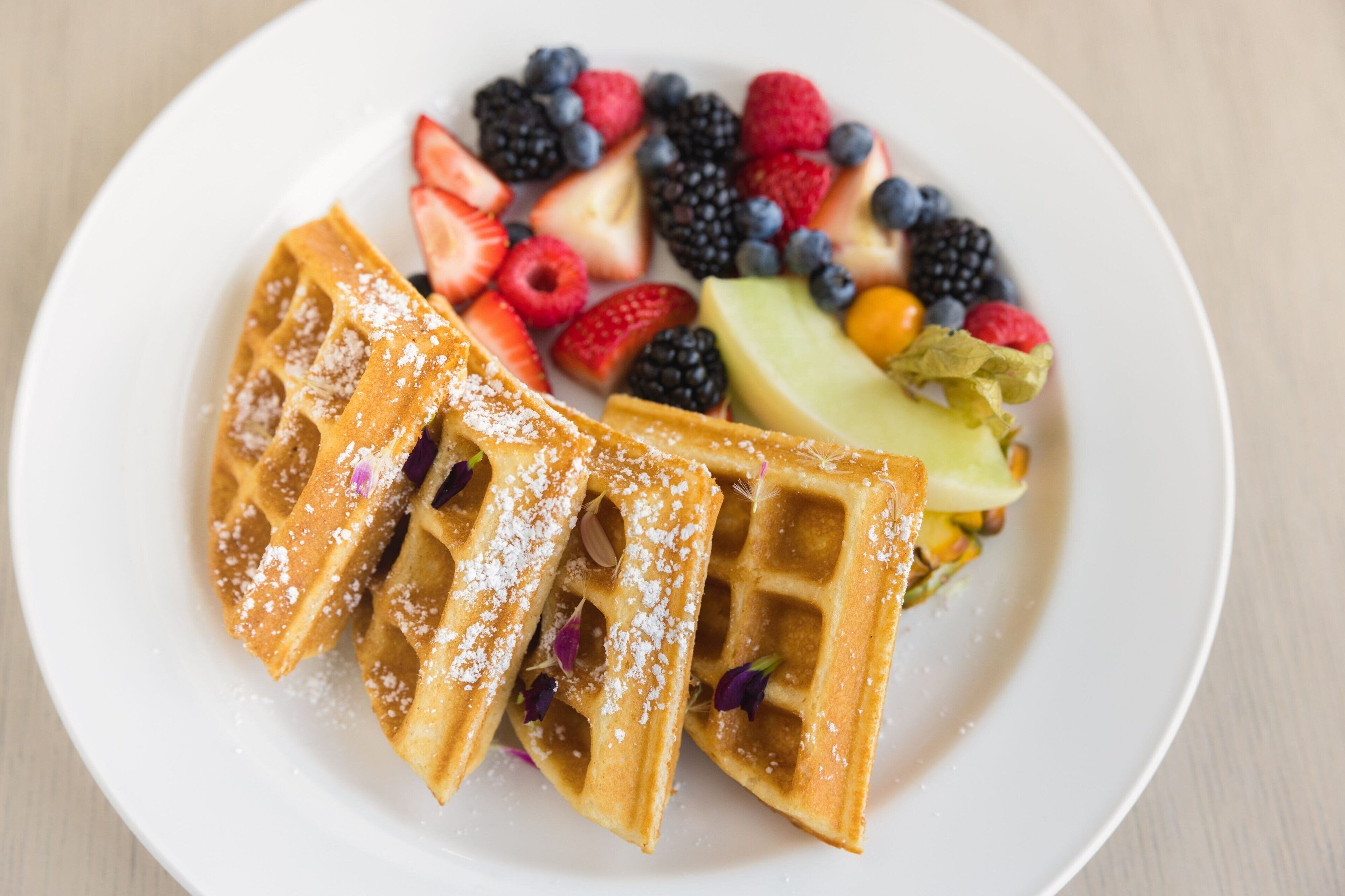 A plate with waffles and assorted fresh berries.