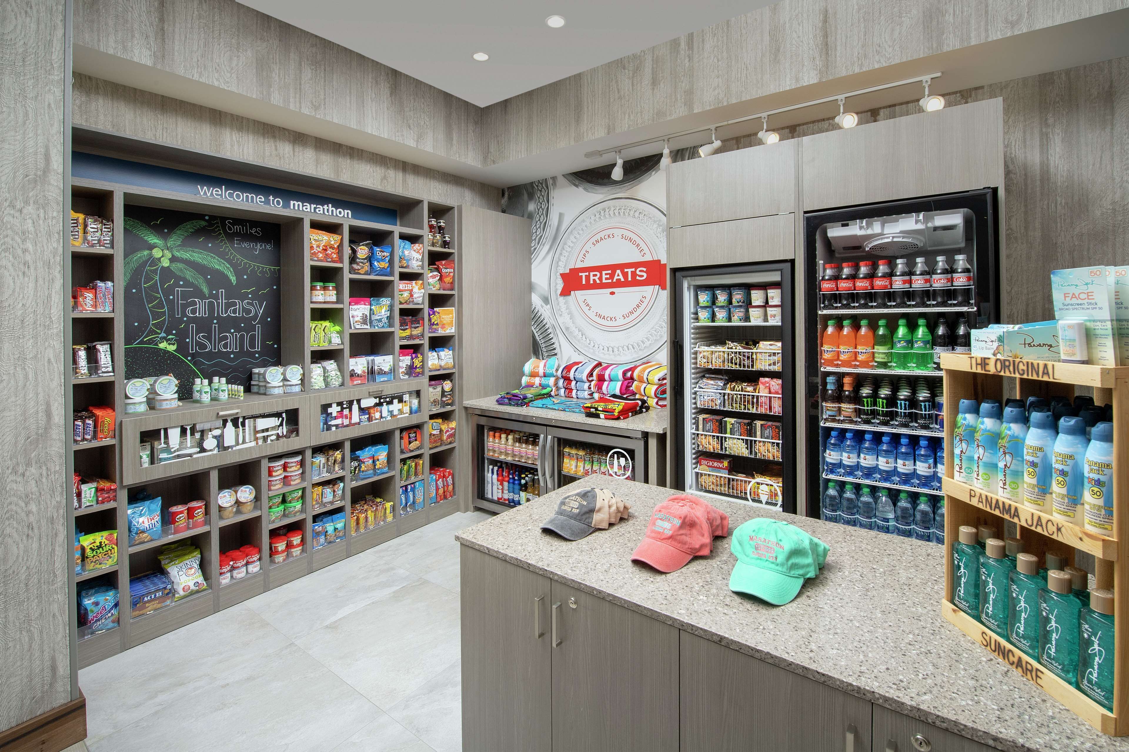 Una tienda con estantes llenos de aperitivos, bebidas y productos de cuidado personal.