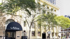 A building with a large arched entrance labeled "Adina".