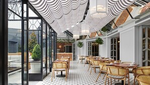 A restaurant with a modern interior, featuring a patterned floor, wooden chairs, and a ceiling with striped fabric. - The Royce (Melbourne)