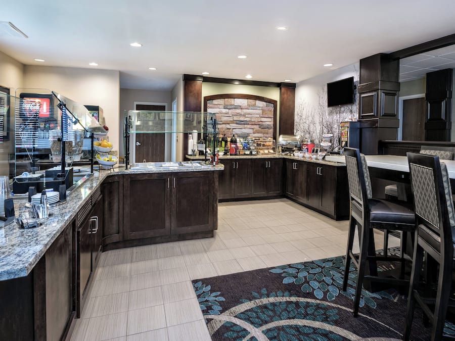 Una cocina moderna con encimeras de granito, muebles oscuros y una isla central.