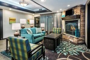 A modern living room with a fireplace, a sofa set, and a coffee table. - Staybridge Suites Lubbock - University Area by IHG (Lubbock)