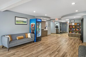 A lobby with a reception desk, a Pepsi refrigerator, a sofa with cushions, and snack shelves. - Best Western Ocala Park Centre (Ocala)