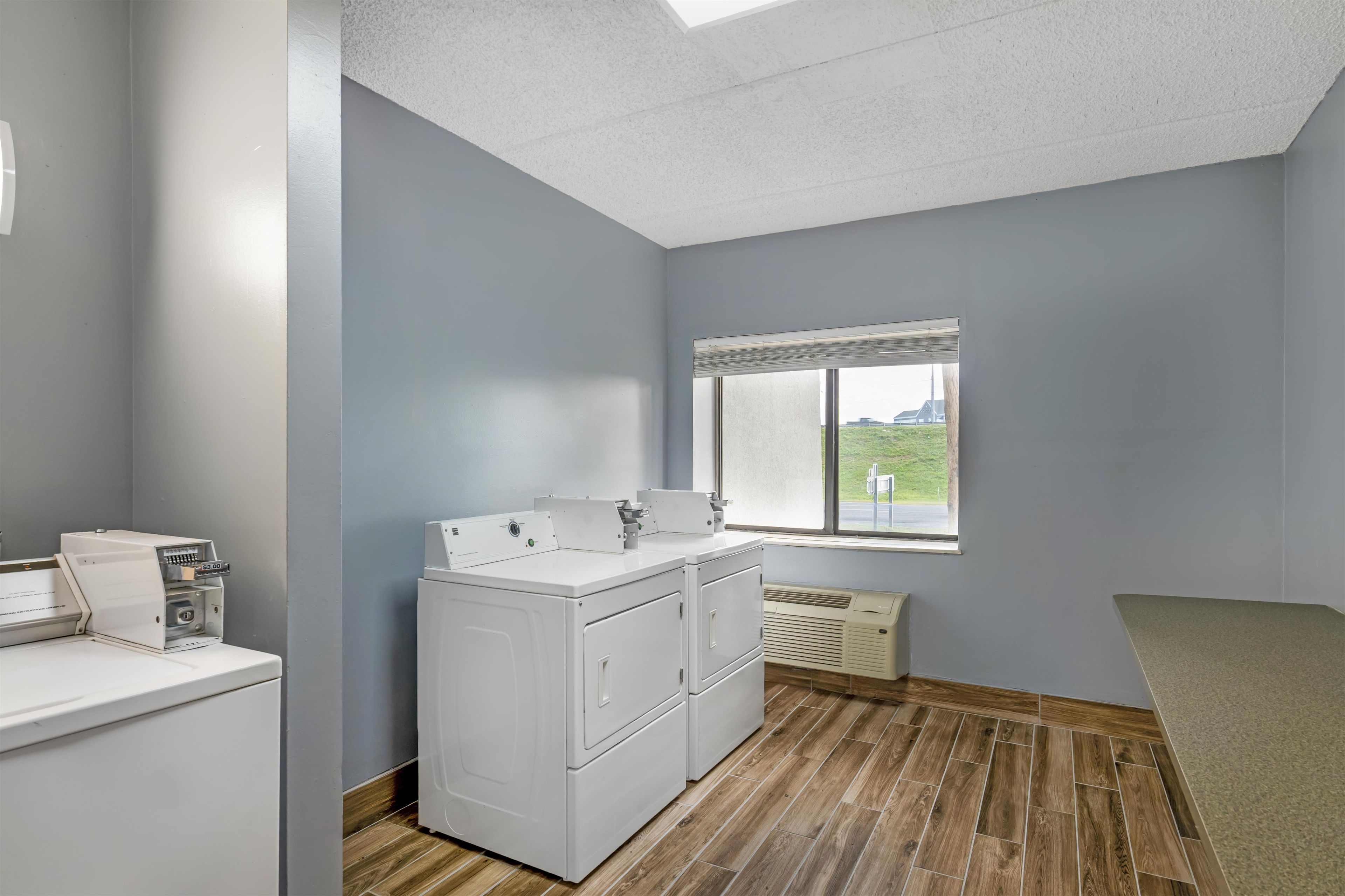 A laundry room with a washing machine, dryer, and stacked laundry baskets.