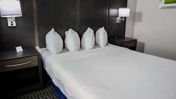 A hotel room with a large bed, two bedside tables, and two wall-mounted lamps.
