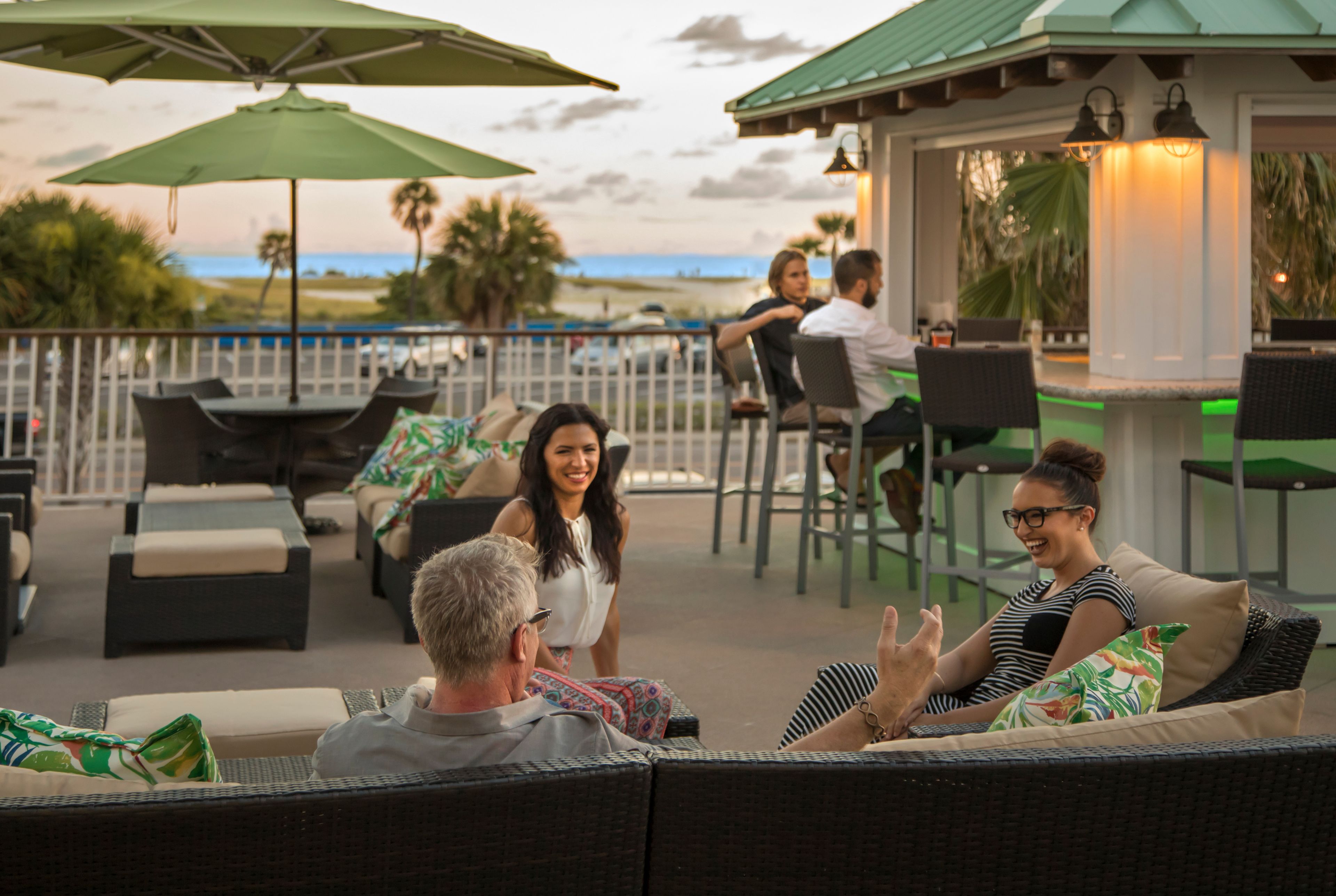 Un espace extérieur aménagé avec des meubles en osier, un bar et une vue sur la plage.