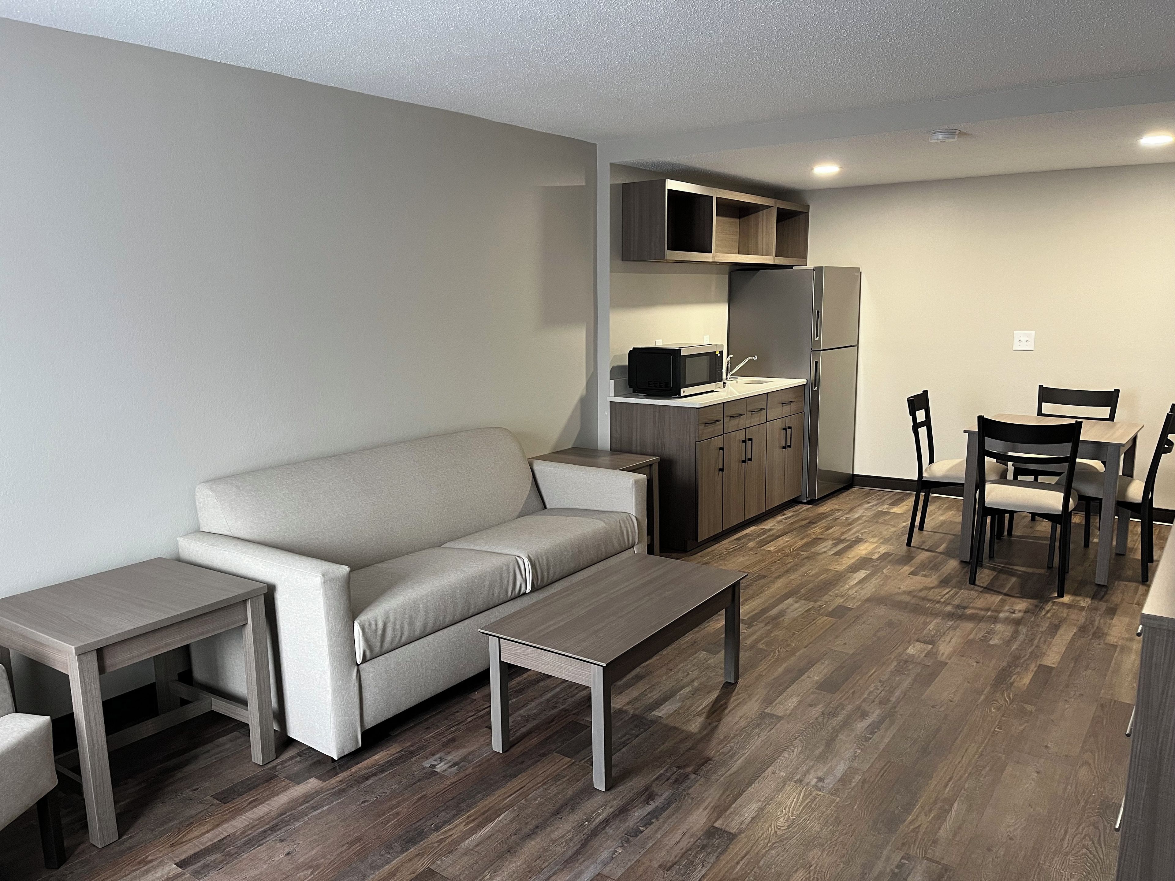 A compact living space with a sofa, a dining table, and a kitchenette.